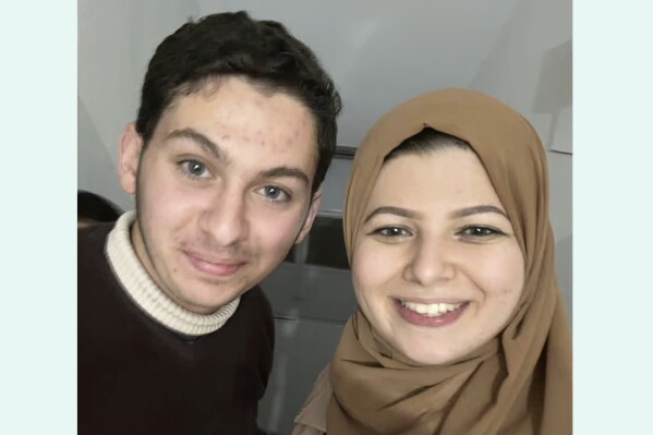 This undated image provided by Yasmeen Elagha shows Elagha, right, with her cousin Borak Alagha. Relatives of Borak Alagha, 28, and Hashem Alagha, 20, two American brothers trapped in Gaza, say Israeli forces have detained the two U.S. citizens, along with their Canadian father, in a raid on their home early Thursday, Feb. 8, 2024. (Yasmeen Elagha via AP)