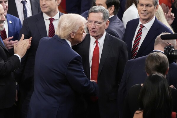 President Donald Trump, left, departs as Sen. John Barrasso, R-Wyo., watches after Trump addressed a joint session of Congress at the Capitol in Washington, Tuesday, March 4, 2025. (AP Photo/Alex Brandon)