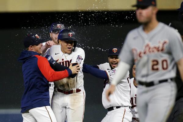 Minnesota Twins third baseman Gio Urshela, center, is congratulated by teammates for a game-winning RBI as Detroit Tigers first baseman Spencer Torkelson (20) leaves the field in conclusion of the ninth inning of a baseball game, Monday, May 23, 2022, in Minneapolis. (AP Photo/Andy Clayton-King)