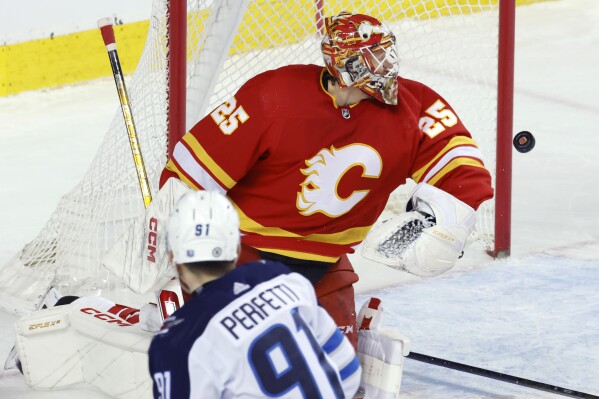 Calgary Flames goalie Jacob Markstrom stops a shot by Winnipeg Jets' Cole Perfetti during the second period of an NHL hockey game in Calgary, Alberta, Monday, Feb. 19, 2024. (Larry MacDougal/The Canadian Press via 番茄直播)
