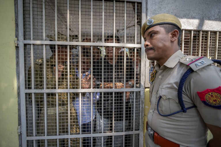 Police hold back opposition Congress party workers from the Assam Pradesh Congress party office to prevent them from protesting against the Citizenship Amendment Act (CAA) in Guwahati, India, Tuesday, March 12, 2024. India has implemented a controversial citizenship law that has been widely criticized for excluding Muslims, a minority community whose concerns have intensified under Prime Minister Narendra Modi's Hindu nationalist government.  The act provides fast-track naturalization for Hindus, Parsis, Sikhs, Buddhists, Jains and Christians who fled to Hindu-majority India from Afghanistan, Bangladesh and Pakistan before December 31, 2014. (AP Photo/Anupam Nath)