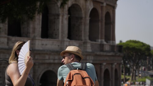 Tourists stops in front of the Colosseum in Rome, Monday, July 17, 2023. Tourist flock to the eternal city while scorching temperatures grip central Italy with Rome at the top of the red alert list as one of the hottest cities in the country. (AP Photo/Gregorio Borgia)