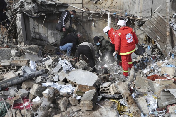 Paramedic workers search for victims in the rubble of a paramedic center that was destroyed by an Israeli airstrike early Wednesday in Hebbariye village, south Lebanon, Wednesday, March 27, 2024. The Israeli airstrike on a paramedic center linked to a Lebanese Sunni Muslim group killed several people of its members. The strike was one of the deadliest single attacks since violence erupted along the Lebanon-Israel border more than five months ago. (AP Photo/Mohammed Zaatari)