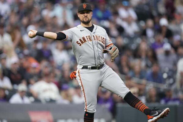 San Francisco Giants third baseman J.D. Davis throws to first base to put out Colorado Rockies' Brian Serven in the third inning of a baseball game against the Saturday, Aug. 20, 2022, in Denver. (AP Photo/David Zalubowski)