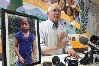 
              FILE - In this Dec. 15, 2018, file photo, Annunciation House director Ruben Garcia answers questions from the media after reading a statement from the family of Jakelin Caal Maquin, pictured at left, during a press briefing at Casa Vides in downtown El Paso, Texas. An autopsy has found that the 7-year-old girl from Guatemala who was detained by the U.S. Border Patrol died of a bacterial infection. Jakelin died on Dec. 8, just over a day after she was apprehended by Border Patrol agents with her father. (Rudy Gutierrez/The El Paso Times via AP, File)
            