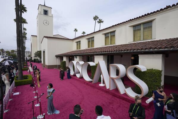 Maria Bakalova, from left, Andra Day and Regina King are interviewed and Marlee Matlin walks the red carpet at the Oscars on Sunday, April 25, 2021, at Union Station in Los Angeles. (AP Photo/Mark Terrill, Pool)