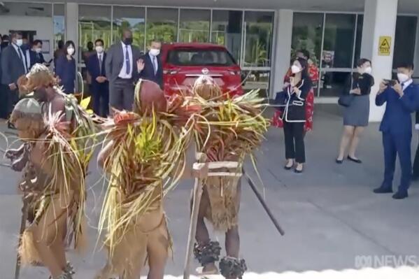 In this image taken from video, China's Foreign Minister Wang Yi waves to indigenous dancers as he arrives in Port Vila, Vanuatu. Yi arrived in Vanuatu on Wednesday for talks as he continued his regional island-hopping tour two days after failing to ink an ambitious deal with 10 South Pacific nations. (Australian Broadcasting Corporation via AP)
