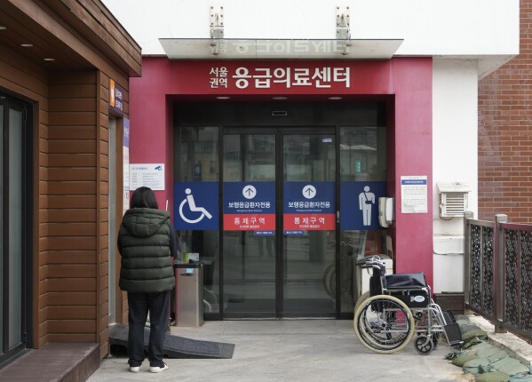 Una mujer se encuentra afuera de un centro de emergencia en el Hospital Universitario Nacional en Seúl, Corea del Sur, el jueves 29 de febrero de 2024. El gobierno de Corea del Sur ha hecho un último llamamiento a los médicos jóvenes para que pongan fin a una huelga, a pocas horas del final.  Fecha límite el jueves para sus amenazas de suspender licencias médicas y procesar a los huelguistas.  (Foto AP/Ahn Young-joon)