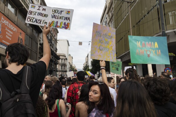 FILE - People raise placards as they participate in the annual Pride parade, in Athens, on June 10, 2023. Greece's center-right government said on Thursday, Dec. 21, 2023, it would fulfill a commitment to legalize same-sex marriage, sidestepping staunch opposition from the country's influential Orthodox Church. (AP Photo/Yorgos Karahalis, File)