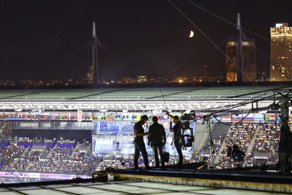 Actor Tom Cruise stands on the roof of the Stade de France  during the closing ceremony of the 2024 Summer Olympics, at the Stade de France, Sunday, Aug. 11, 2024, in Saint-Denis, France. (Fabrizio Bensch/Pool Photo via AP)
