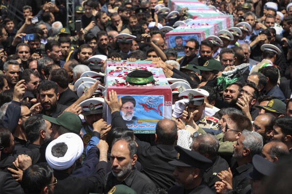 Una imagen difundida por la Oficina de la Presidencia Iraní muestra los ataúdes, envueltos en banderas, del presidente Ebrahim Raisi y quienes lo acompañaban en el choque del helicóptero en que viajaban el domingo, durante su funeral en la ciudad de Mashhad, Irán, el jueves 23 de mayo de 2024.. (Oficina de la Presidencia Iraní vía AP)