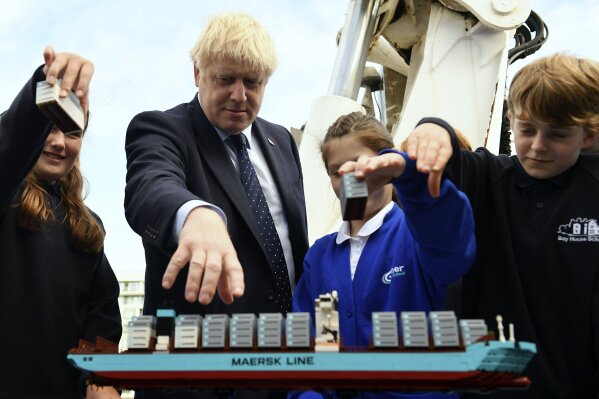 Britain's Prime Minister Boris Johnson takes part in an activity with school children as he visits the NLV Pharos, a lighthouse tender moored on the river Thames, to mark London International Shipping Week in London, Thursday, Sept. 12, 2019. The British government insisted Thursday that its forecast of food and medicine shortages, gridlock at ports and riots in the streets after a no-deal Brexit is an avoidable worst-case scenario, as Prime Minister Boris Johnson denied misleading Queen Elizabeth II about his reasons for suspending Parliament just weeks before the country is due to leave the European Union. (Daniel Leal-Olivas/Pool photo via AP)