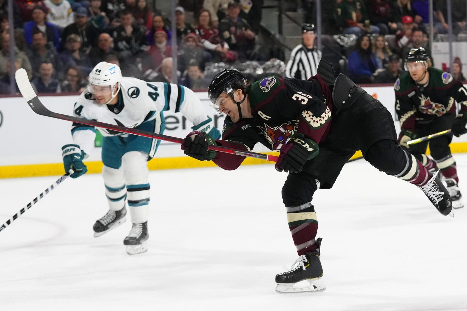 Arizona Coyotes defenseman Josh Brown (3) lands a punch during a fight  against San Jose Sharks center Michael Eyssimont as linesman Devin Berg,  left, looks on during the first period of an