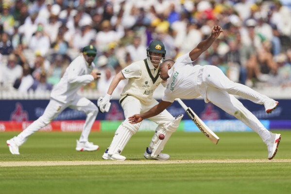 South Africa's Kagiso Rabada, right, dives to field the ball on his own delivery during the World Test Championship final between South Africa and Australia at Lord's cricket ground in London, Wednesday, June 11, 2025. (AP Photo/Kirsty Wigglesworth)