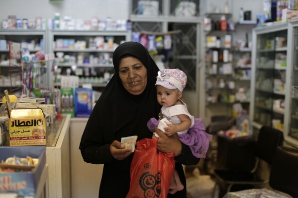FILE - A Syrian woman leaves a pharmacy after buying medicine in Damascus, Syria, on July 24, 2019. The Syrian government decided to increase prices of drugs by 50%, the head of the pharmacies syndicate in Damascus said Tuesday Aug. 8, 2023 as the Syrian pound hit new a low in recent days. (AP Photo/Hassan Ammar, File)