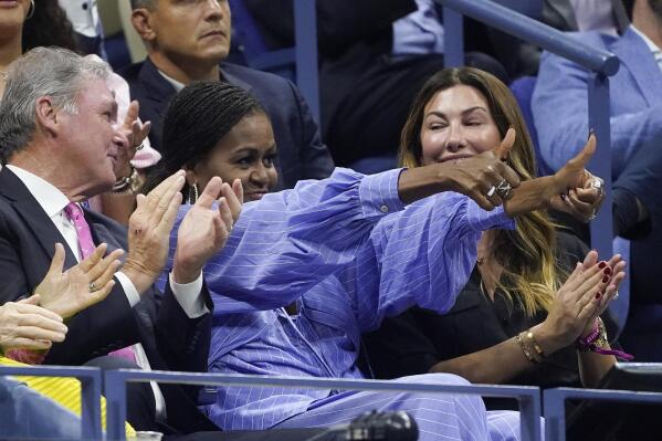 Michelle Obama, center, gives two thumbs up to Frances Tiafoe, of the United States, during a semifinal match between Tiafoe and Carlos Alcaraz, of Spain, at the U.S. Open tennis championships, Friday, Sept. 9, 2022, in New York. (AP Photo/John Minchillo)