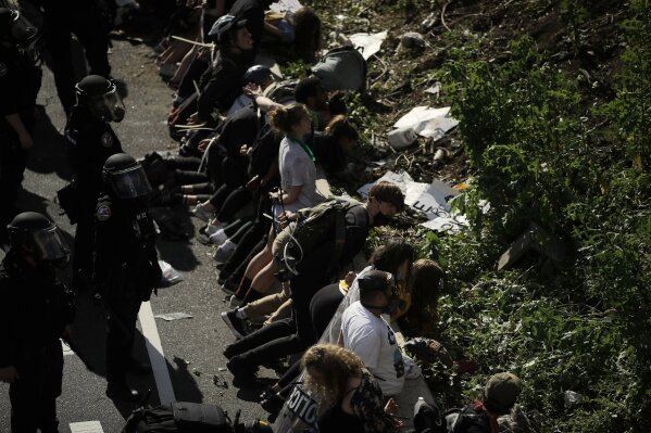 FILE - In this June 1, 2020 file photo, police detain protesters in the aftermath of a march calling for justice over the death of George Floyd on Interstate 676 in Philadelphia.  An independent review of Philadelphia’s police response to days of widespread protests over police brutality after the May killing of George Floyd found failures in planning that led to short staffing, emotional responses from police officers and sometimes excessive uses of force. The 110-page report released Wednesday, Dec. 23,  was commissioned by Mayor Jim Kenney as an independent review of operations during the protests.  (AP Photo/Matt Rourke, File)