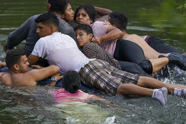 Migrants cross the Rio Grande River on an air mattress from Matamoros, Mexico, to the US on May 9, 2023.  (AP Photo/Fernando Llano, File)