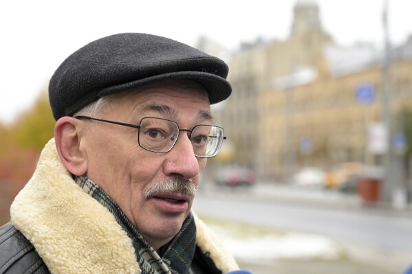 FILE - Oleg Orlov, a member of the Board of the International Historical Educational Charitable and Human Rights Society 'Memorial' (International Memorial), speaks to journalists at the monument, a large boulder from the Solovetsky islands, where the first camp of the Gulag political prison system was established, near the building of the Federal Security Service (FSB, Soviet KGB successor) in Lubyanskaya Square in Moscow, Russia, Sunday, Oct. 29, 2023. A court in Russia on Thursday, Dec. 14, overturned a fine handed to Orlov for speaking out against the war in Ukraine and sent Orlov's case back to prosecutors, who have sought to imprison him for three years instead. (AP Photo/Dmitry Serebryakov, File)