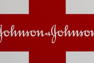 This Feb. 24, 2021 photo shows a Johnson & Johnson logo on the exterior of a first aid kit in Walpole, Mass. The New York attorney general says Johnson & Johnson has agreed to pay $230 million to settle claims that the pharmaceutical giant helped fuel the opioid crisis. The deal requires Johnson & Johnson to make a series of payments over nine years to cover total. (AP Photo/Steven Senne)