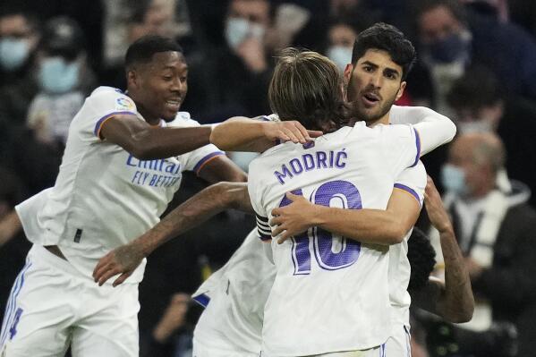 Real Madrid's team players celebrate after Marco Asensio, right, scored their side's second goal during the Spanish La Liga soccer match between Real Madrid and Atletico Madrid at Santiago Bernabeu stadium in Madrid, Spain, Sunday, Dec. 12, 2021. (AP Photo/Bernat Armangue)