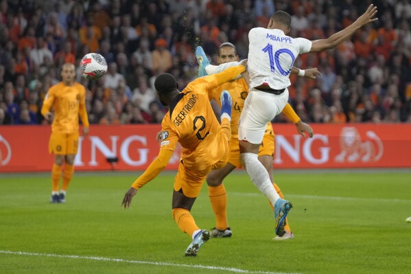 France's Kylian Mbappe, right, scores his side's opening goal during the Euro 2024 group B qualifying soccer match between The Netherlands and France at the Johan Cruyff ArenA stadium in Amsterdam, Netherlands, Friday, Oct. 13, 2023. (AP Photo/Peter Dejong)