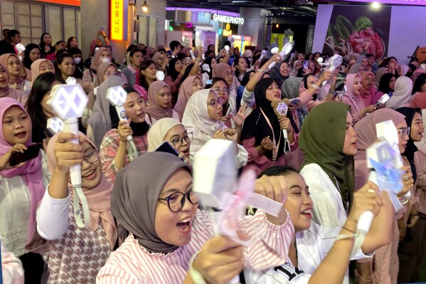 Fans sing along to a K-pop song during an event organized by a cosmetic brand collaborating with a South Korean boy band, at a shopping mall in Jakarta, Indonesia, Sunday, Feb. 4, 2024. As Indonesia votes this month to replace popular President Joko Widodo, all three candidates have all been aggressively seeking to win the votes of younger people, reaching out to them on the apps they use, through the K-pop music many love, and even video gaming events. (AP Photo/Dita Alangkara)