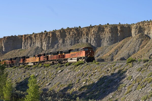 A train transports freight on a common carrier line near Price, Utah on Thursday, July 13, 2023. Uinta Basin Railway, which would connect to common carrier lines, could be an 88-mile line in Utah that would run through tribal lands and national forest to move oil and gas to the national rail network. Critics question investing billions in oil and gas infrastructure as the country seeks to use less of the fossil fuels that worsen climate change. (AP Photo/Rick Bowmer)