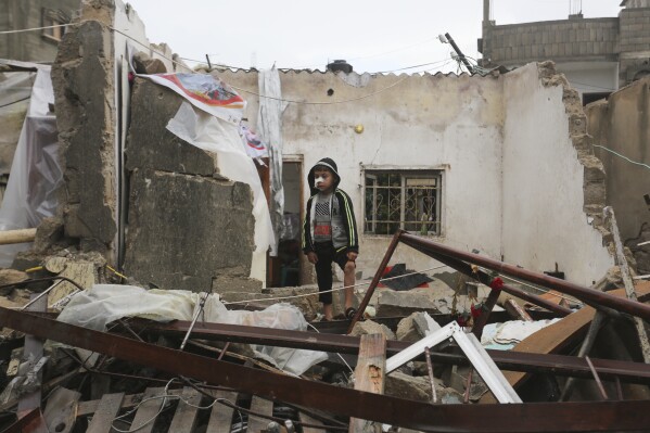 A Palestinian boy stands among the destruction after Israeli strikes on Rafah, Gaza Strip, Wednesday, Nov. 15, 2023. (AP Photo/Hatem Ali)