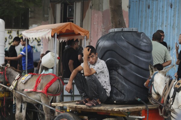 Palestinians arrive to collect drinking water during the ongoing Israeli bombardment of the Gaza Strip in Rafah on Saturday, Oct. 28, 2023. (AP Photo/Hatem Ali)