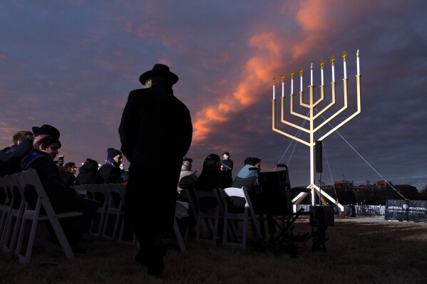 A man returns to his seat during the National Chanukah Menorah lighting, Thursday, Dec. 7, 2023, on the Ellipse near the White House in Washington. (AP Photo/Jacquelyn Martin)