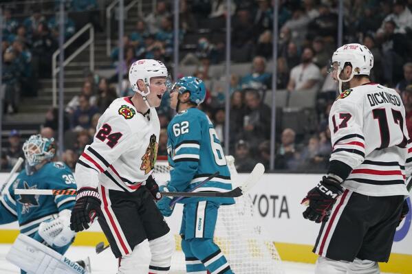 Chicago Blackhawks center Sam Lafferty (24) celebrates with Jason Dickinson (17) after scoring against the San Jose Sharks during the second period of an NHL hockey game in San Jose, Calif., Saturday, Oct. 15, 2022. (AP Photo/Godofredo A. Vásquez)