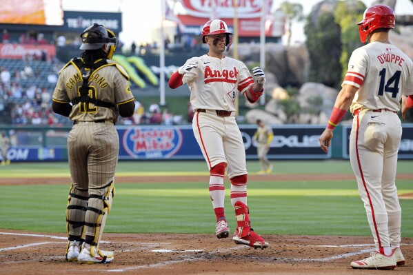 Los Angeles Angels' Zach Neto, center, celebrates with Logan O'Hoppe, right, after hitting a two-run home run as San Diego Padres catcher Luis Campusano stands at the plate during the second inning of a baseball game Wednesday, June 5, 2024, in Anaheim, Calif. (AP Photo/Mark J. Terrill)