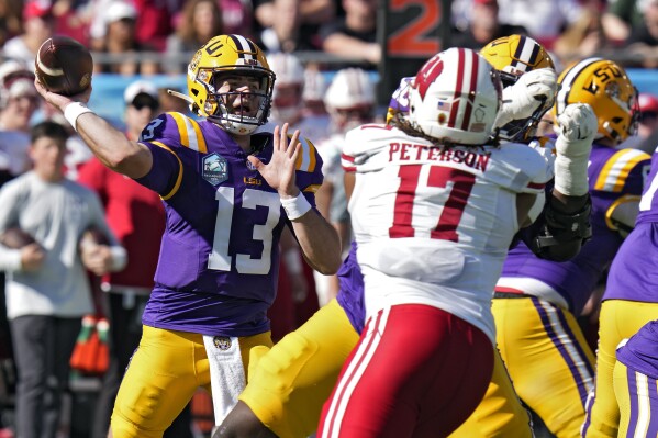 LSU quarterback Garrett Nussmeier (13) throws a pass as he is pressured by Wisconsin linebacker Darryl Peterson during the first half of the ReliaQuest Bowl NCAA college football game Monday, Jan. 1, 2024, in Tampa, Fla. (AP Photo/Chris O'Meara)