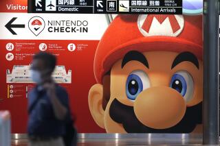 FILE - A traveler walks past an advertisement featuring a Nintendo character at Narita airport in Narita near Tokyo Friday, June 10, 2022. A Saudi sovereign wealth fund now holds 8.26% of the stock in the video game maker Nintendo, making it the largest outside investor in the Japanese gaming company, a company filing said Friday, Feb. 17, 2023. (AP Photo/Shuji Kajiyama, File)