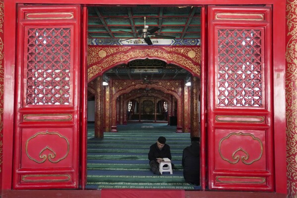 A Muslim reads the Quran while waiting for the time to break his fast during the first day of Ramadan at the Niujie Mosque in Beijing, China, Tuesday, March 12, 2024. (AP Photo/Tatan Syuflana)