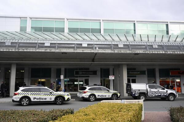 Australian Federal Police attend the Canberra Airport in Canberra, Sunday, Aug. 14, 2022, after a shooting incident. An Australian man is charged with three weapons offenses Monday, Aug. 15, after he allegedly used a handgun inside the Canberra Airport to fire multiple shots at airport windows. (Mick Tsikas/AAP Image via AP)