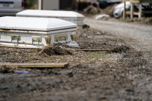Caskets that floated from their tombs during flooding from Hurricane Ida sit along a roadside in Ironton, La., Monday, Sept. 27, 2021. Hurricane Ida swept through Louisiana with furious winds that ripped roofs off buildings and storm surge so powerful it moved homes. And what it wrought on the living it also wrought on the dead, moving vaults and caskets and adding another layer of trauma on families and communities recovering from the powerful storm. (AP Photo/Gerald Herbert)
