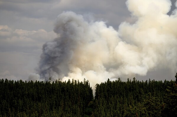 Smoke billows from the Donnie Creek wildfire burning north of Fort St. John, British Columbia, on Sunday, July 2, 2023. (AP Photo/Noah Berger)