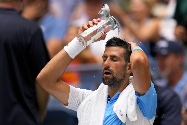 Novak Djokovic, of Serbia, pours water on his head to cool off between sets against Taylor Fritz, of the United States, during the quarterfinals of the U.S. Open tennis championships, Tuesday, Sept. 5, 2023, in New York. (AP Photo/Manu Fernandez)