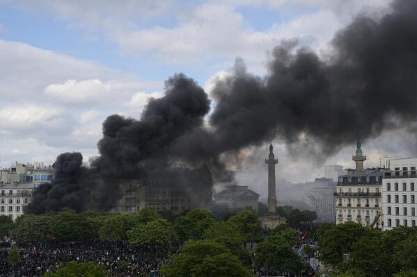 Smoke billows on Place de la Nation after youths set a fire during a demonstration, Monday, May 1, 2023 in Paris. Across France, thousands marched in what unions hope are the country's biggest May Day demonstrations in years, mobilized against President Emmanuel Macron's recent move to raise the retirement age from 62 to 64. (AP Photo/Thibault Camus)