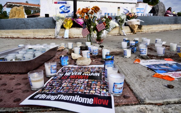 Flowers and candles are left at a makeshift shrine placed at the scene of a Sunday confrontation that lead to death of a demonstrator, Tuesday, Nov. 7, 2023, in Thousand Oaks, Calif. Paul Kessler, 69, died at a hospital on Monday from a head injury after witnesses reported he was involved in a "physical altercation" during pro-Israel and pro-Palestinian demonstrations at an intersection in Thousand Oaks, a suburb northwest of Los Angeles, authorities said. (AP Photo/Richard Vogel)