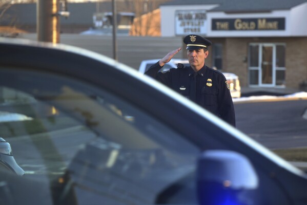 Sioux Falls Police Lt. Andrew Siebenborn salutes a passing law enforcement procession carrying the remains of Moody County Chief Deputy Sheriff Kenneth Prorok on Monday, Feb. 5, 2024, in Sioux Falls, S.D. Prorok was killed on Friday, Feb. 2, after being struck by a car while putting out spikes during a police chase following an attempted traffic stop. (Dominik Dausch /The Argus Leader via AP)