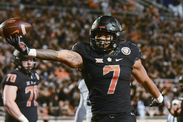 Oklahoma State running back Jaylen Warren (7) celebrates following his touchdown during the first half of the team's NCAA college football game against TCU on Saturday, Nov. 13, 2021, in Stillwater, Okla. (AP Photo/Brody Schmidt)
