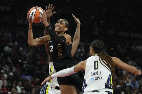 Las Vegas Aces forward A'ja Wilson (22) shoots over Dallas Wings forward Satou Sabally (0) during the first half in Game 2 of a WNBA basketball semifinal series Tuesday, Sept. 26, 2023, in Las Vegas. (AP Photo/John Locher)