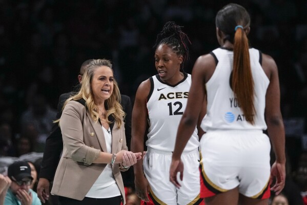 Las Vegas Aces head coach Becky Hammon talks to Chelsea Gray (12) and Jackie Young (0) during the first half in Game 3 of a WNBA basketball final playoff series against the New York Liberty, Sunday, Oct. 15, 2023, in New York. (AP Photo/Frank Franklin II)