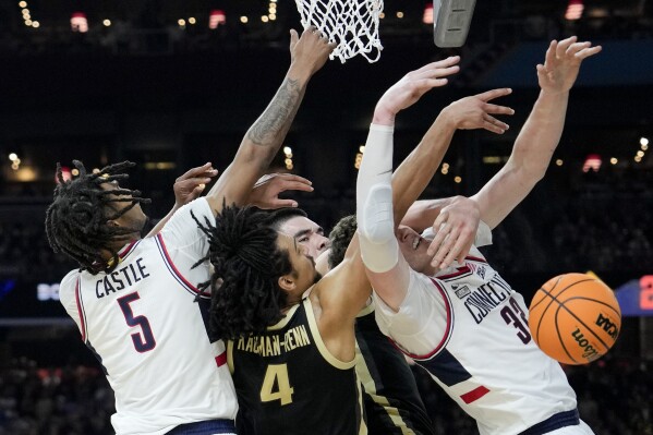 Purdue forward Trey Kaufman-Renn (4) vies for the ball with UConn center Donovan Clingan (32) during the first half of the NCAA college Final Four championship basketball game, Monday, April 8, 2024, in Glendale, Ariz. (AP Photo/David J. Phillip)