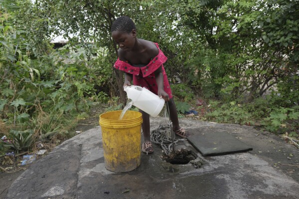 A young girl fetches water from a well in Lilanda township in Lusaka, Zambia, Saturday March 9, 2024. (AP Photo/Tsvangirayi Mukwazhi)