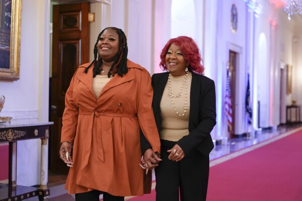 FILE - Presidential Citizens Medal honorees Shaye Moss, a former Georgia election worker, left, and her mother Ruby Freeman arrive in the East Room of the White House in Washington, Jan. 6, 2023, for a ceremony to mark the second anniversary of the Jan. 6 assault on the Capitol and to award Presidential Citizens Medals. The pressure campaign and threats against the two Georgia election workers figured prominently in this week's indictment of Donald Trump.(AP Photo/Patrick Semansky, File)