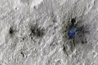 This undated photo released by NASA shows craters that were formed by a Sept. 5, 2021, meteoroid impact on Mars, the first to be detected by NASA’s InSight. Taken by NASA’s Mars Reconnaissance Orbiter, this enhanced-color image highlights the dust and soil disturbed by the impact in blue in order to make details more visible to the human eye. NASA lander on Mars has captured the vibrations and sounds of four meteorites striking the planet's surface. Scientists reported Monday, Sept. 19, 2022, that Mars InSight detected seismic and acoustic waves from a series of impacts in 2020 and 2021. (NASA/JPL-Caltech/University of Arizona via AP)
